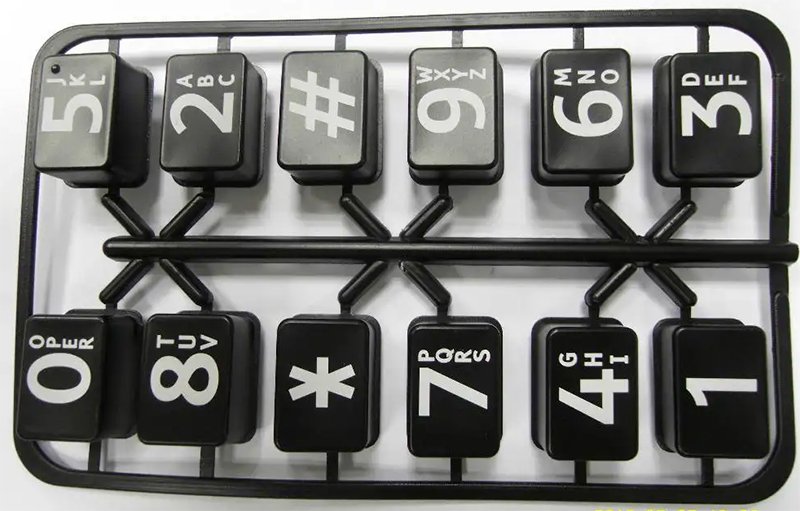 white laser marking on black molded electronic buttons